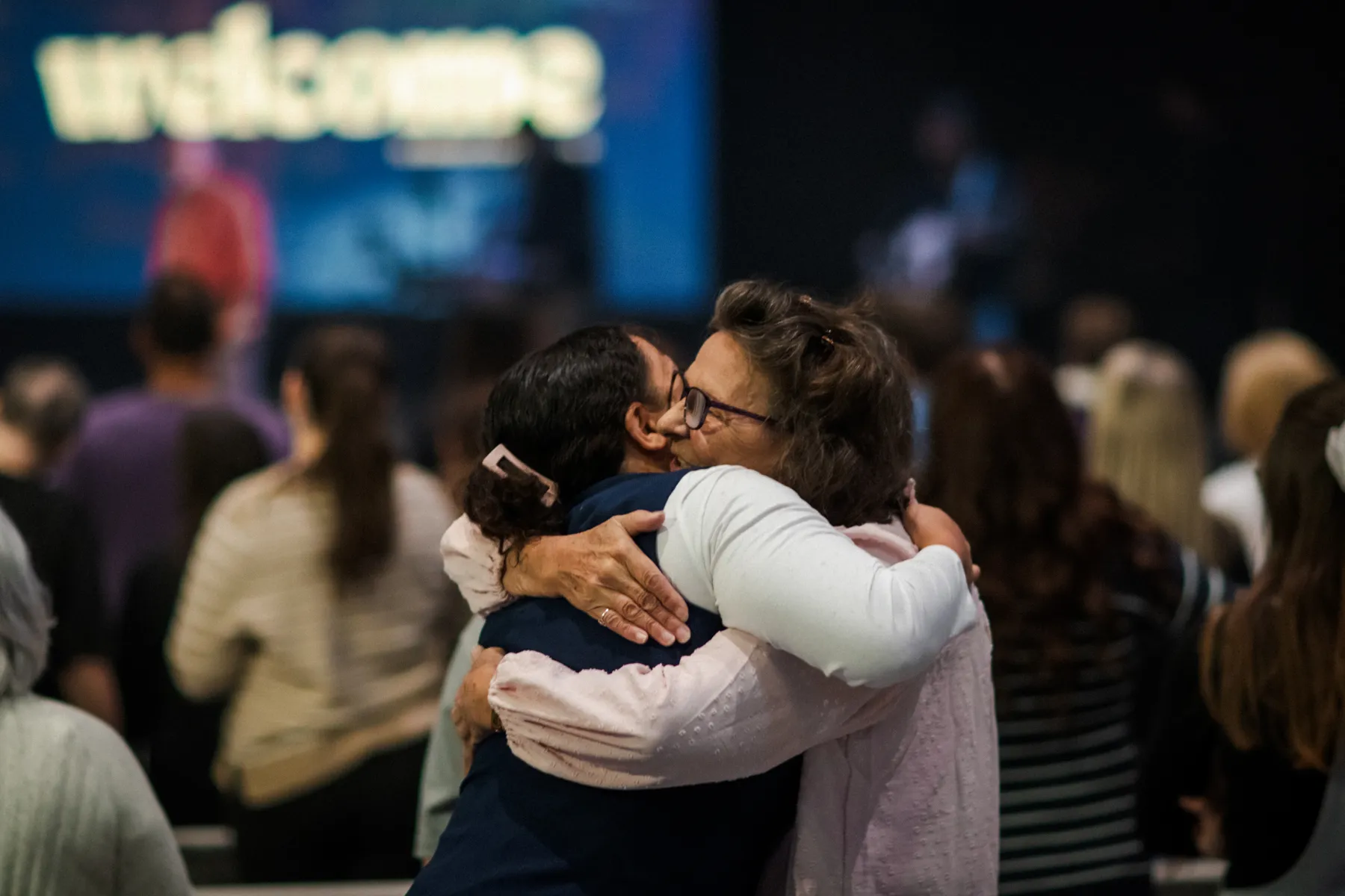 Two women sharing a hug during a Sunday service