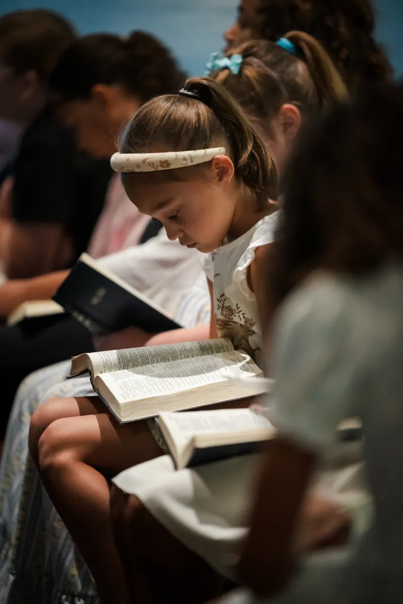 A girl reading her Bible during service