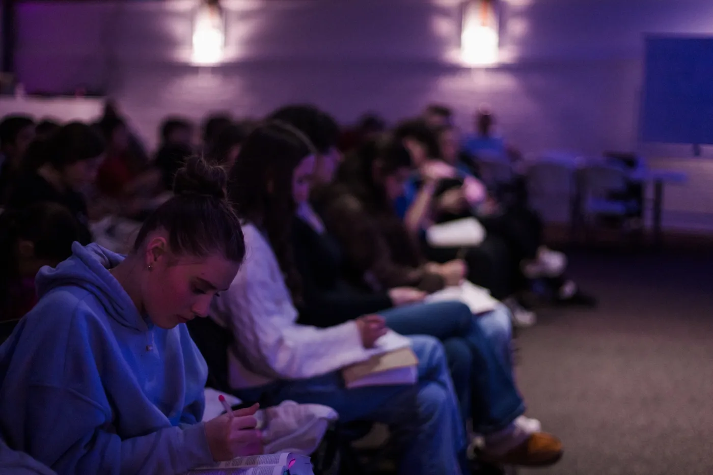 Students following along in their Bibles during youth night
